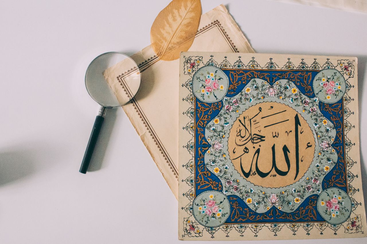 Services Elegant Arabic calligraphy with colorful floral motifs and magnifying glass on pale background.