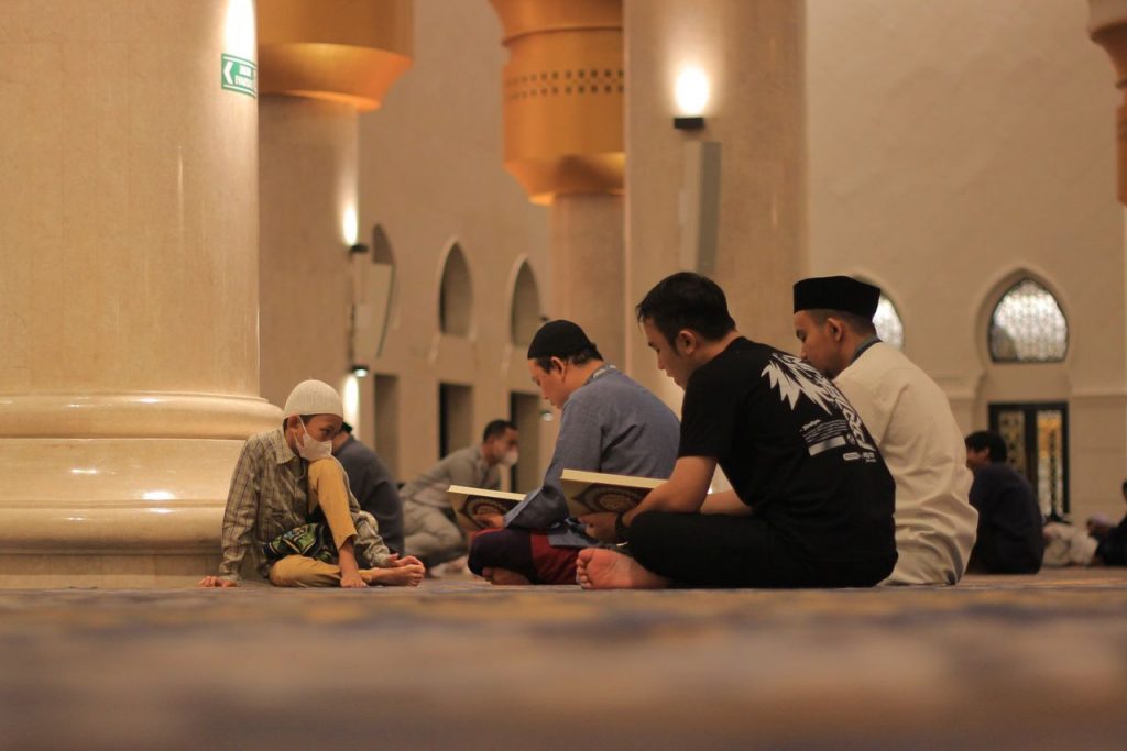 Muslim men engage in Quran reading inside a beautifully designed mosque in Indonesia.