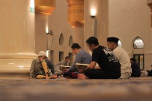 Muslim men engage in Quran reading inside a beautifully designed mosque in Indonesia.